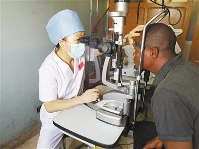 中国专家正在为贝宁当地患者进行眼科检查。本报记者 黄培昭摄
