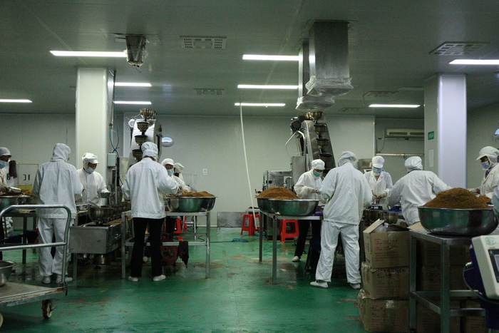 马山县南华糖厂金伦红糖生产车间内,工人正在包装制好的红糖.