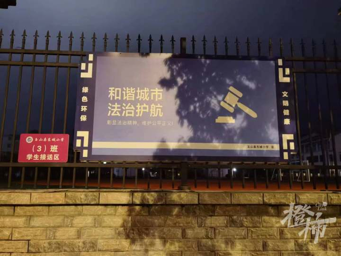 玉山县东城小学的墙上，贴着“和谐城市 法治护航”的标语