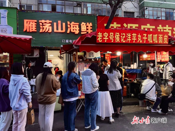 游客在光明巷夜市排队购买天水特色小吃。