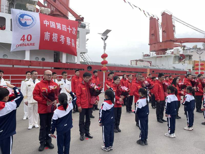 少先队员向考察队员代表献花。新京报记者 张建林 摄