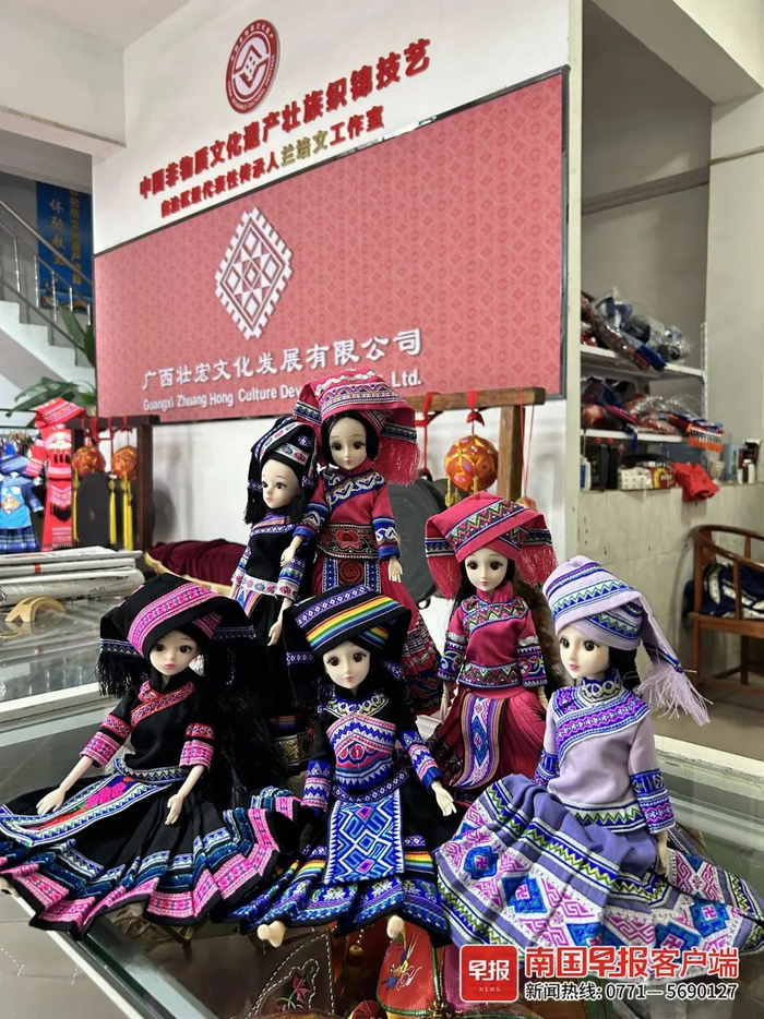 ▲兰培文的工作室里展示着精致的壮锦民族娃娃。