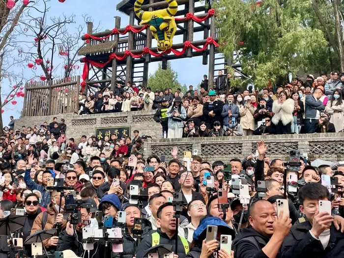 围观的人都举起了手机。罗晓兰摄