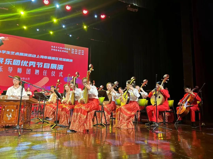 杨浦区建设小学的孩子们身着色彩鲜艳的服装,手持民族乐器合奏民乐