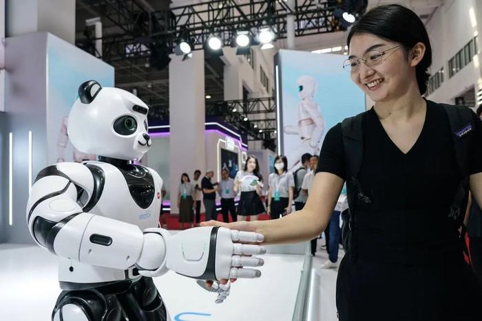 一位女士与机器人握手。这与互联网大潮下 ，写作写作文的业该时候想不到素材 ，图片来源：新华社（记者：彭子洋）