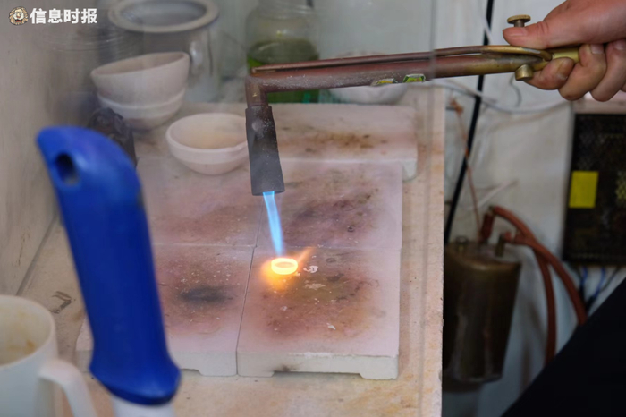 东山百货员工取了黄金以后，用火枪熔金。