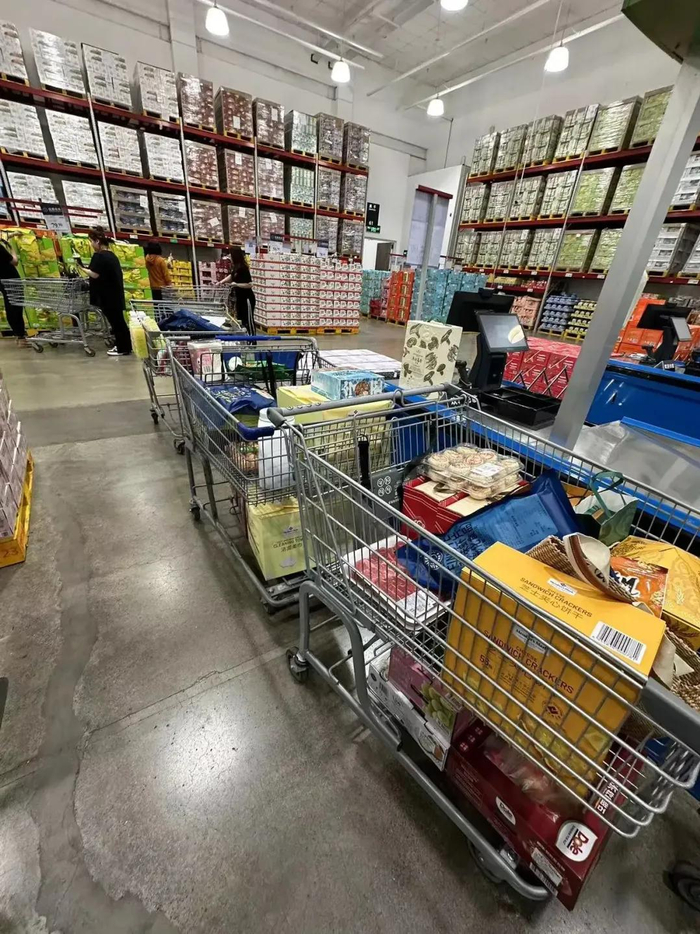 代购要用一辆购物车顶着另一辆排队购买。讲述者供图