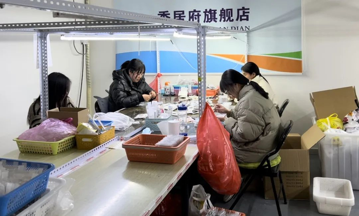 穿戴甲基地里，负责质检的女性工作人员。（图/时代周报记者王晨婷 摄）