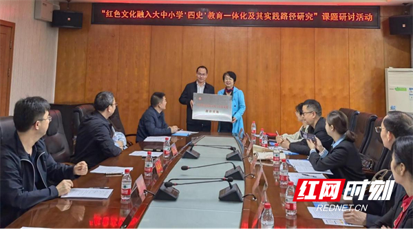 常德市三中党委书记王宸安从湖南幼专科研处处长欧阳前春手中接过"