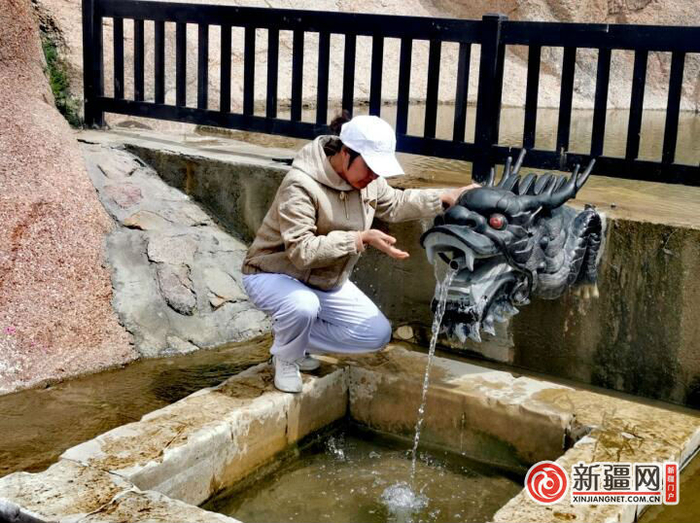 游客在神龙泉景区龙头处打卡