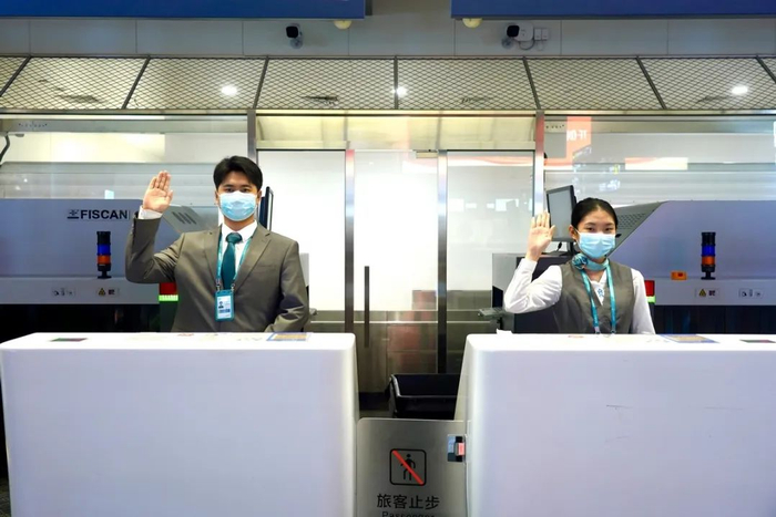 海口美兰国际机场2号航站楼内值机员为旅客办理值机手续