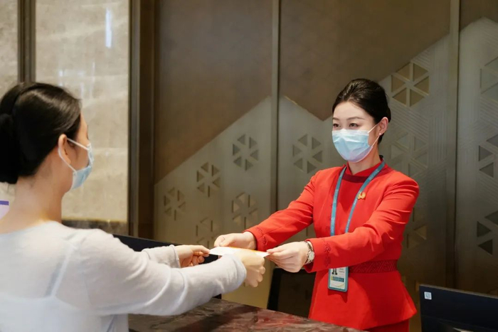 海口美兰国际机场贵宾室，贵宾服务人员正在给旅客办理登机手续