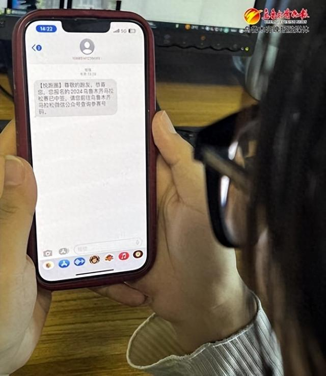 　　一位参与者查看收到的2024乌鲁木齐马拉松参赛资格信息。记者王畅彤摄