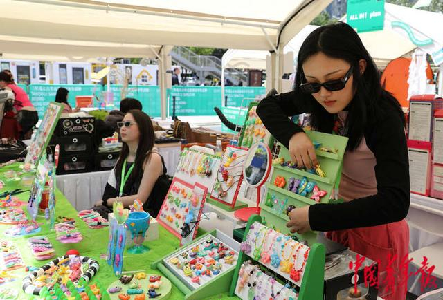 4月30日，北京，2024年京港澳青年生活节集市，齐云雪（右）在摊位前整理售卖的饰品。中青报·中青网记者 陈剑／摄