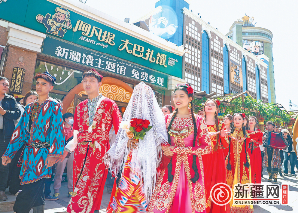 5月1日，婚礼秀的接亲仪式在大巴扎步行街举行。（全媒体记者米热扎提·木塔力甫摄）