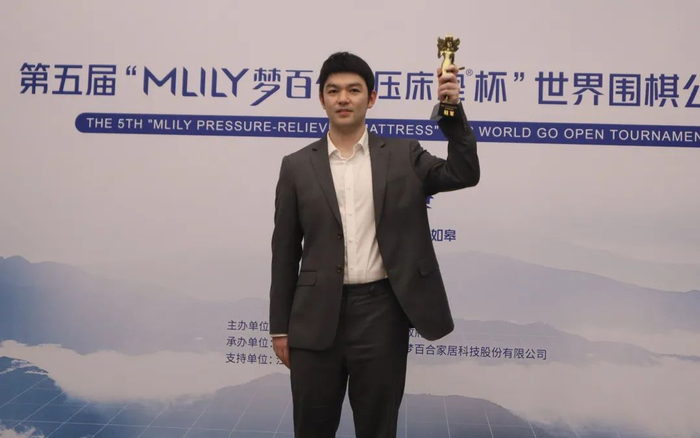 ▲李轩豪举起冠军奖杯。中国围棋协会供图
