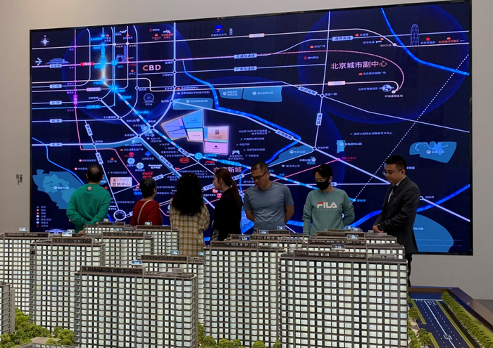 （北京亦庄某新房项目售楼处沙盘前看房的人。张达/摄）