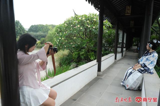 姜策兰（左）在南宁市花卉公园为小胡拍摄照片