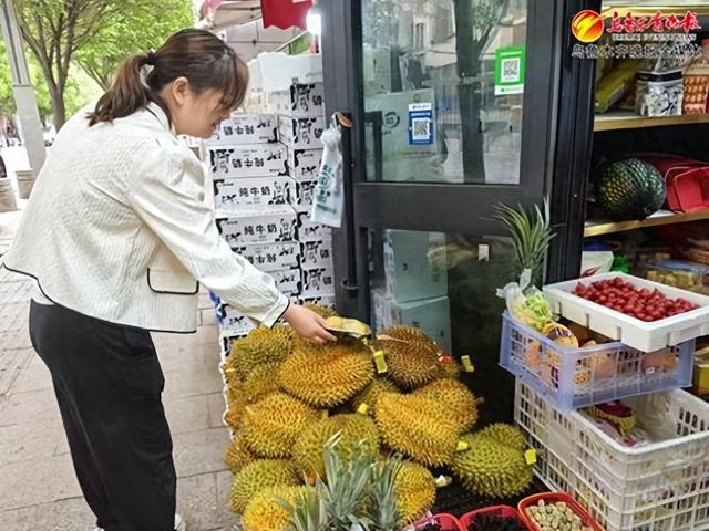 　　 5月7日，在前进街一家水果店，市民正在选购榴莲。记者王璇摄