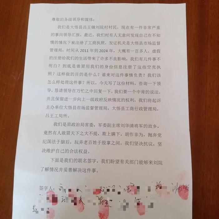 刘院村村民写签名信，希望调查身份被冒用事件。受访者供图