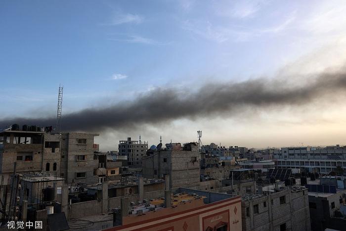 当地时间2024年5月10日，以色列在加沙地带南部的拉法进行轰炸后，日出时建筑物上方升起烟雾。（图源：视觉中国）