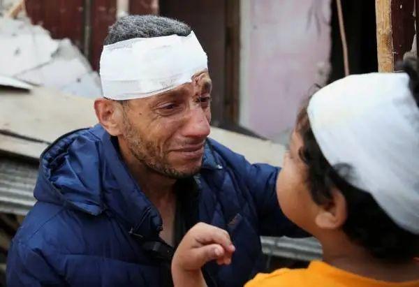 遭受以色列恐袭受伤的巴勒斯坦父子在废墟上（图片来源：ICphoto）