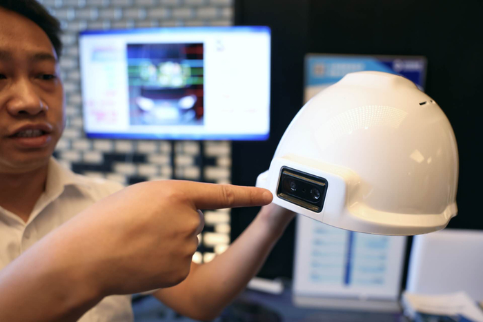 企业在展示AI智能安全帽。新京报记者 浦峰 摄