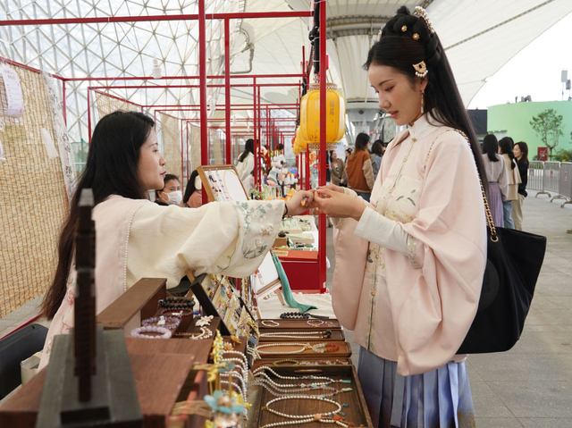 4月11日，华服爱好者在上海“世博源”的国风市集上挑选饰品。新华社记者刘颖 摄