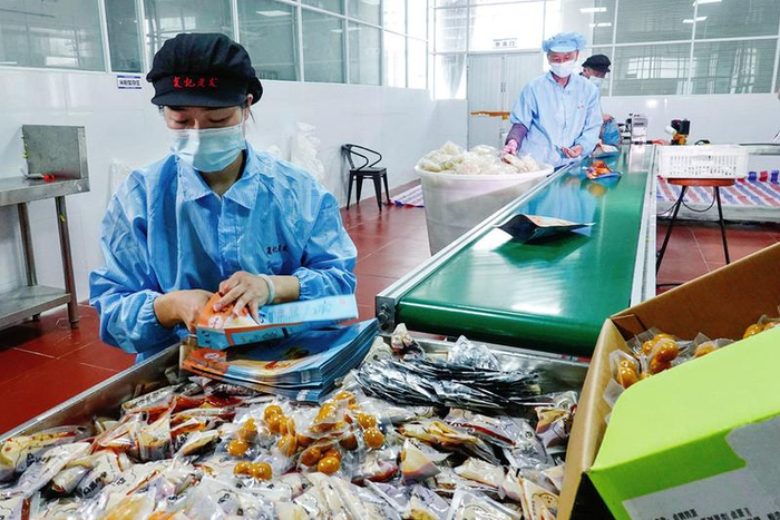 位于广西—东盟经开区的广西复记食品科技有限公司生产车间，工人在包装生产线上作业。本报记者叶子榕 摄