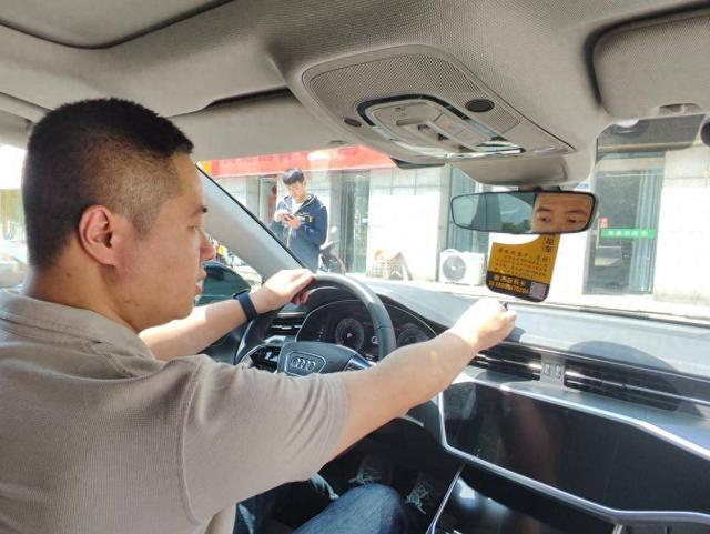 图：神州租车南京分公司经理陈越在查验还回来的一辆奥迪车并挂上已验车的小标识。