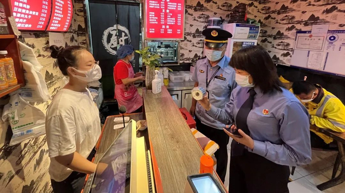 图为前往辖区餐馆查看外卖封签制作使用情况