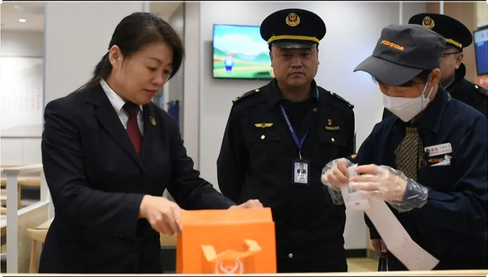 图为前往辖区餐馆现场指导工作人员规范使用外卖封签