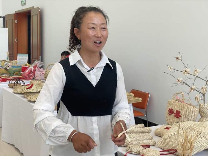张林秀展示她用玉米皮编织的手工品。新京报记者 陈超 摄