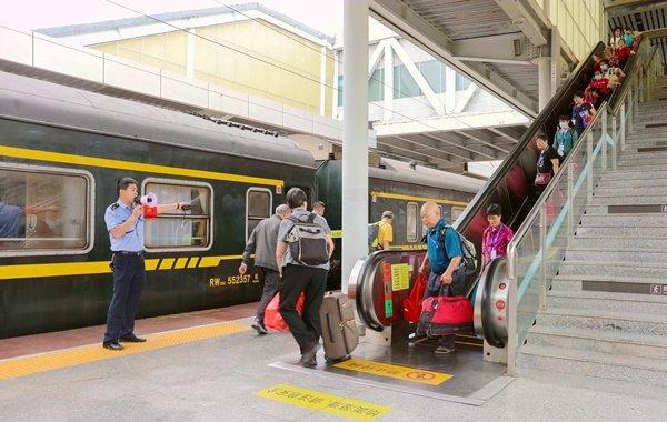 桂林北站客运工作人员在电梯口为银发旅游专列的旅客提供引导服务