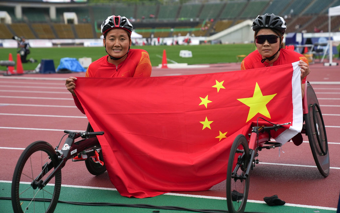 冠军周洪转（左）和亚军高芳在女子100米T53级别决赛后合影。  图/新华社