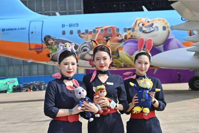 东航乘务员与彩绘机合影。中国东航供图