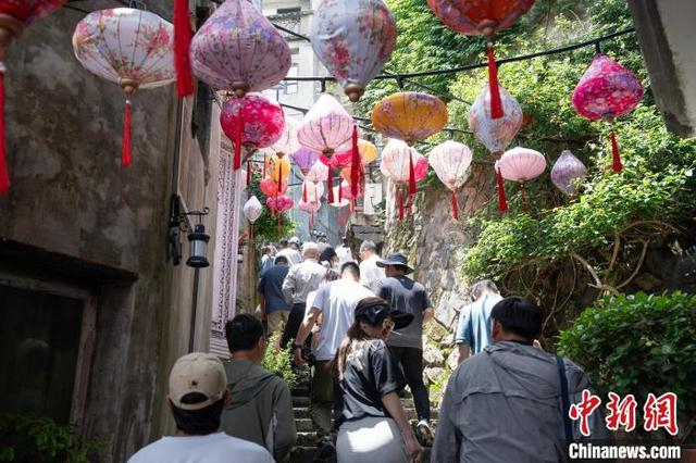 游人行走在挂满“鱼灯”的霞关老街内。吴君毅 摄 