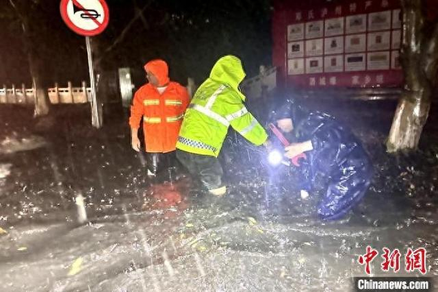 暴雨导致道路积水严重，工作人员正在雨中紧急处理。泸州应急供图
