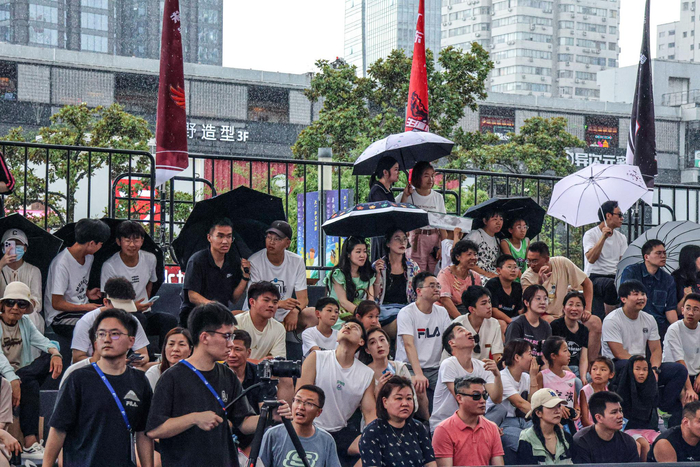 现场比赛球迷冒雨观战。 刘佳和 图