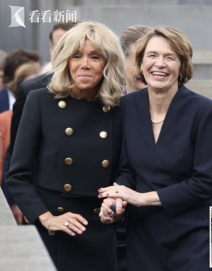 两位总统和夫人向花圈鞠躬后走过纪念碑,法国第一夫人和德国总统夫人