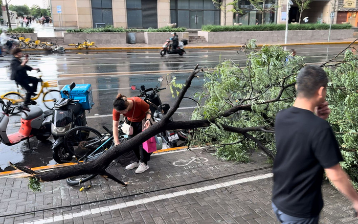 市民扶起被压倒的自行车。新京报记者 王巍 摄