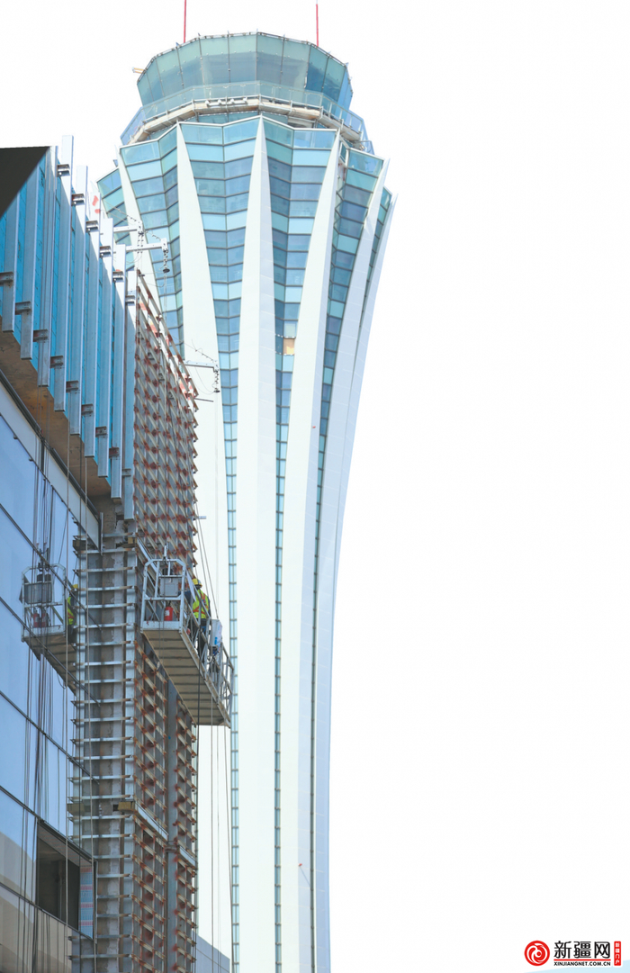 在乌鲁木齐机场改扩建工程交通中心项目，施工人员正在安装外幕墙玻璃。（乌鲁木齐晚报资料图片）