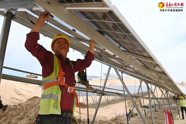 　　4月19日，在米东区北部沙漠光伏基地，工人正在搭建安装光伏板。资料图片