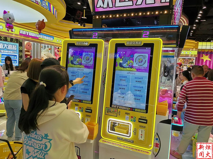 在抓娃娃机前,只需扫码支付就可以购买游戏币.