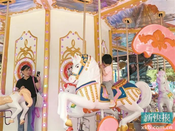 流花湖公园榕荫游乐场，小朋友在玩旋转木马。