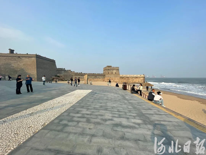 5月10日，秦皇岛市山海关区老龙头景区，游客在入海石城一侧的沙滩上游玩。河北日报记者魏雨摄