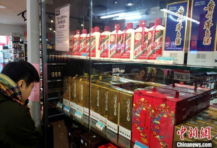 资料图:1月4日,市民在福建福州的一超市贵州茅台酒专柜了解信息