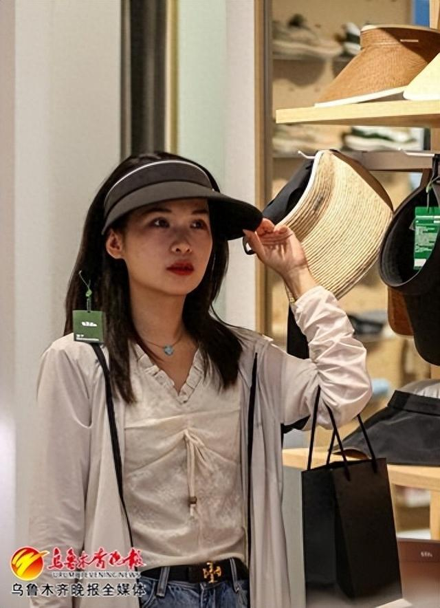 　　6月3日，在位于美美2购物中心的一家店铺，消费者选购防晒帽。记者迪丽娜尔·加力肯摄