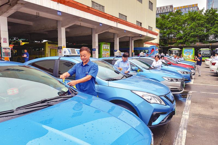 出租车驾驶员给"爱心送考"车辆系上黄丝带,为中高考学子加油.