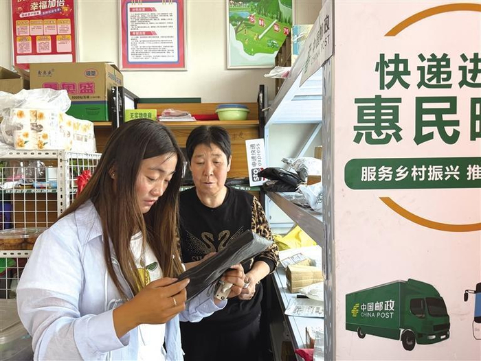     村民在寄递物流综合服务站就近取快递